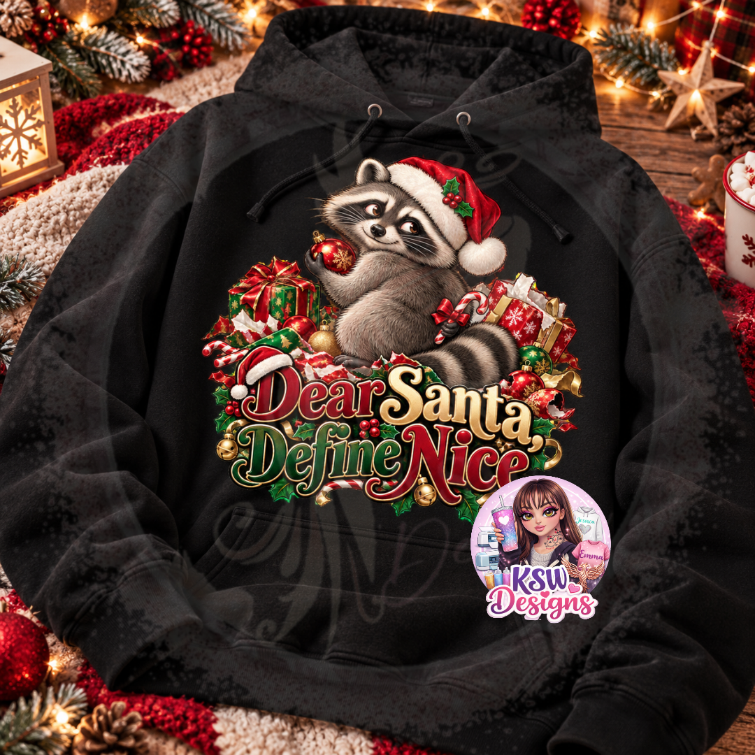 Black pullover Christmas hoodie featuring a raccoon wearing a red Santa hat and holding a bauble, surrounded by presents, candy canes, holly and Dear Santa Define Nice lettering.