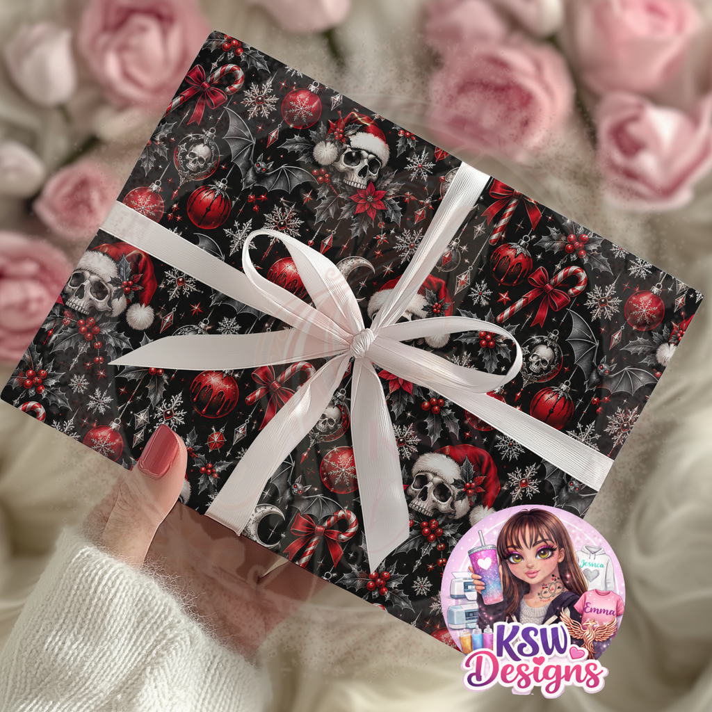 Christmas gift wrapped in black gothic paper featuring skulls wearing Santa hats, black bats, red baubles, candy canes, holly and silver-toned snowflakes, tied with a white ribbon.