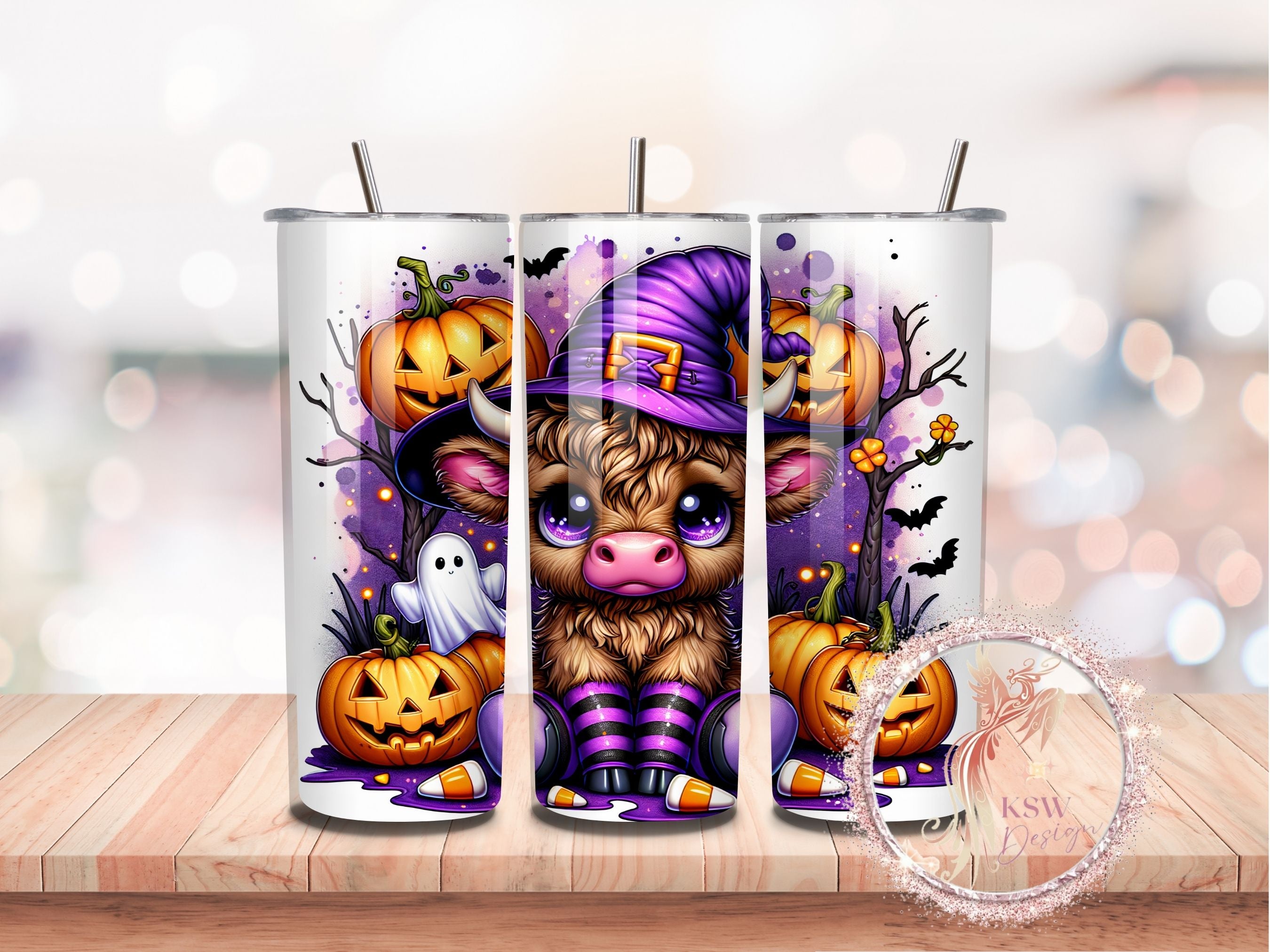 Halloween-themed tumbler with a cow character and pumpkins on a wooden surface.