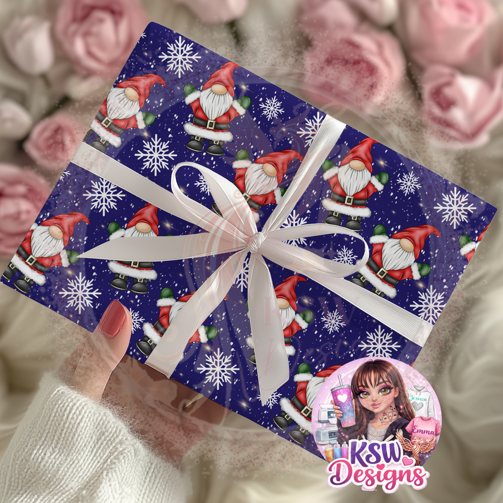 Christmas present wrapped in Midnight Gonk Magic A3 wrapping paper featuring red Santa-style gonks, white snowflakes and twinkling stars on a deep blue background, finished with a white ribbon.