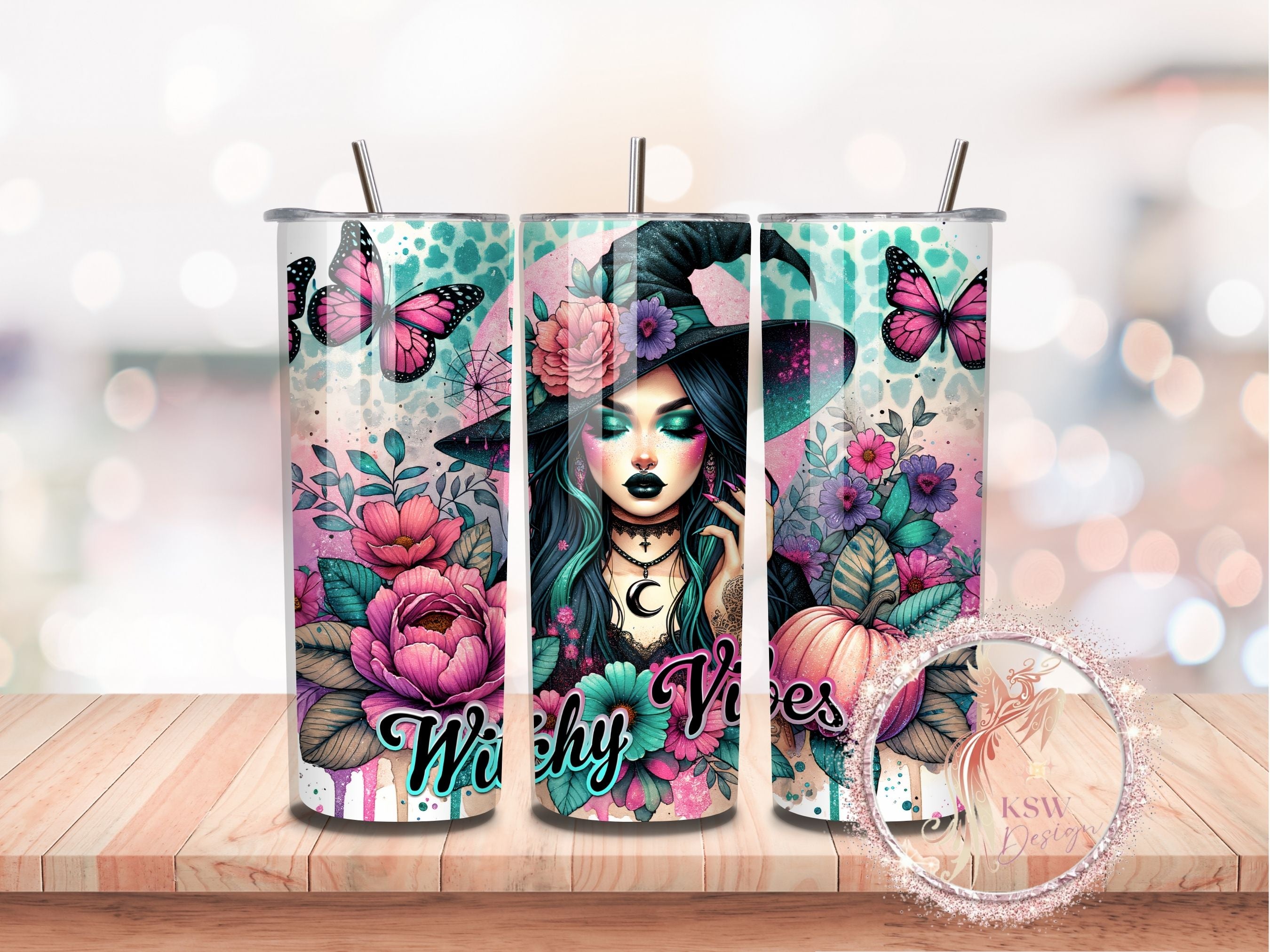 Three tumblers with a witchy design featuring flowers, butterflies, and the text 'Witchy Vibes' on a wooden surface.